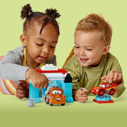 Peuter speelt met LEGO voertuigen en wasstraat.