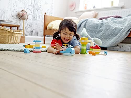 Kind speelt met speelgoed op houten vloer in slaapkamer.
