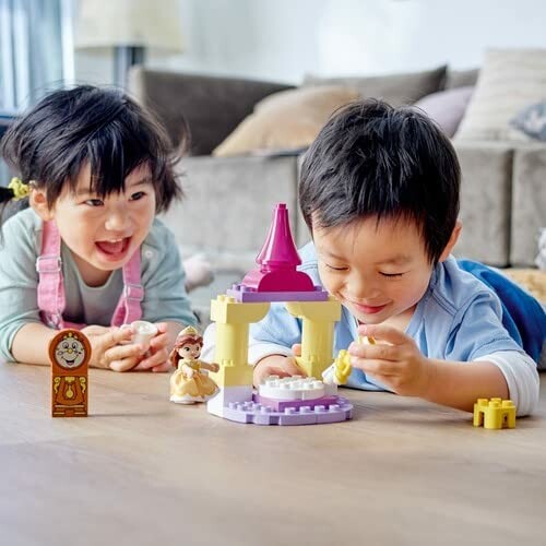 Kinderen spelen met Lego kasteel op de vloer.
