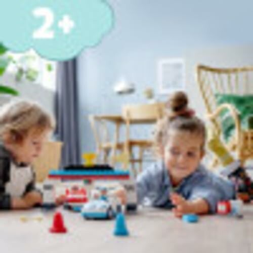 Kinderen spelen met speelgoedauto's op de vloer.