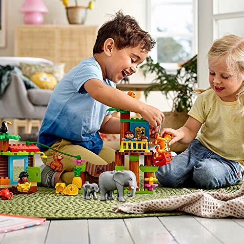 Kinderen spelen met speelgoedblokken op de vloer.