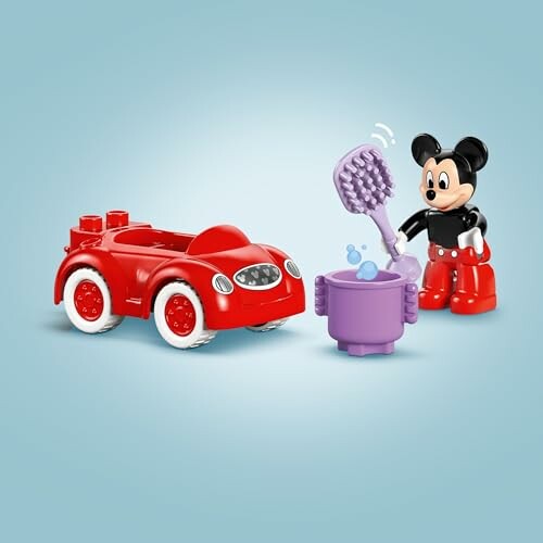 Mickey Mouse speelt met rode speelgoedauto en paarse emmer.