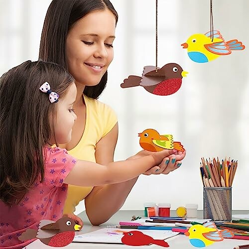 Moeder en dochter maken papieren vogels samen.