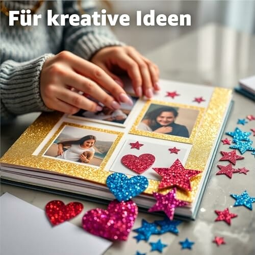 Handen versieren een fotoalbum met glitterharten en sterren.