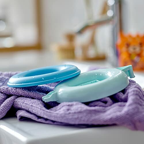 Twee blauwe plastic ringen op paarse handdoek