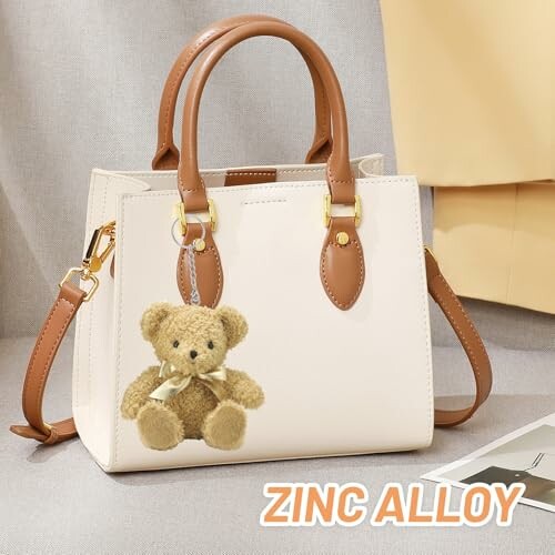 Crèmekleurige handtas met teddybeer sleutelhanger
